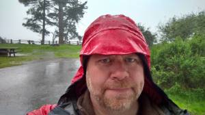 Dave enjoying the rain while breaking camp.